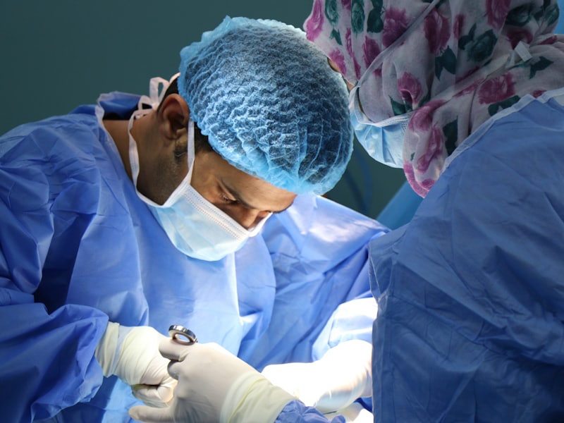 Surgeons in blue scrubs performing an orthopedic procedure