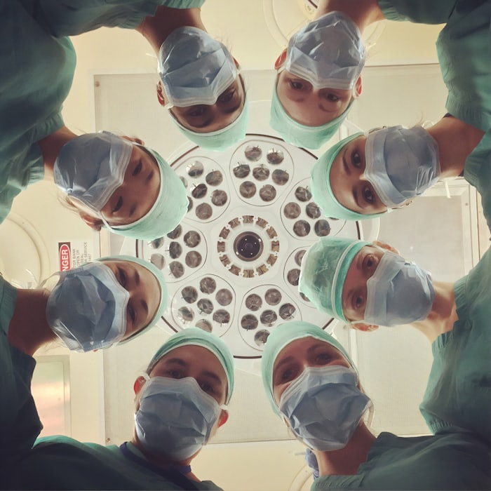Surgical team in caps and masks, seen from the patient’s perspective